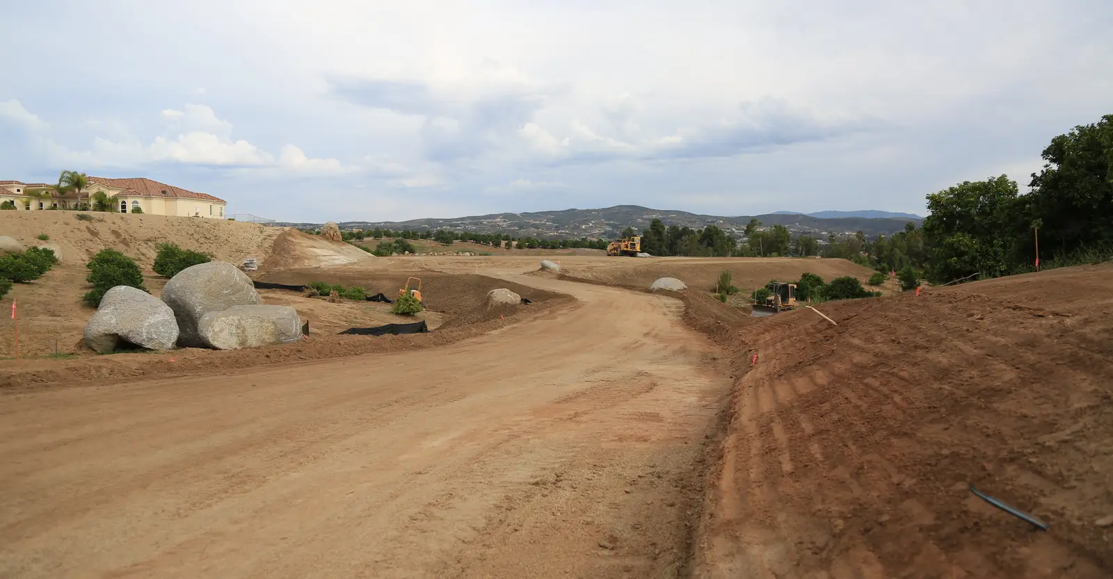 Newly graded access road cut through open land